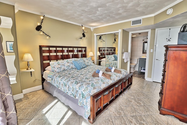 bedroom with connected bathroom, a closet, ornamental molding, and a textured ceiling