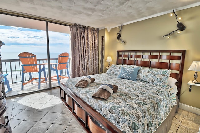 tiled bedroom featuring access to exterior, rail lighting, and a water view