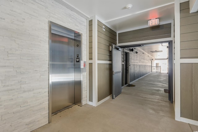 hall with concrete flooring and elevator