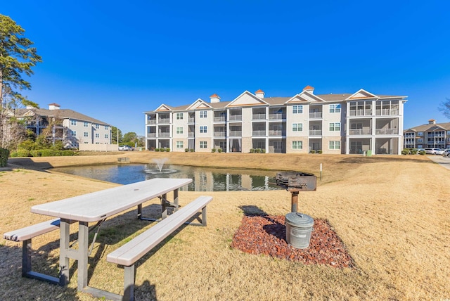 view of community featuring a lawn and a water view