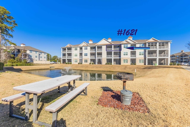 view of home's community featuring a yard and a water view