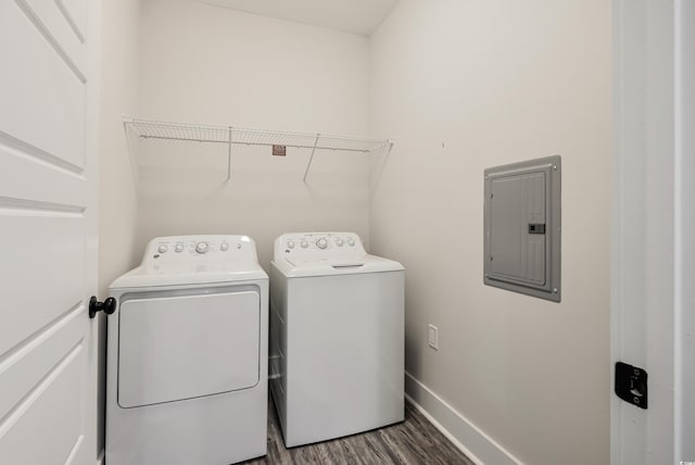 washroom with dark hardwood / wood-style flooring, washing machine and dryer, and electric panel