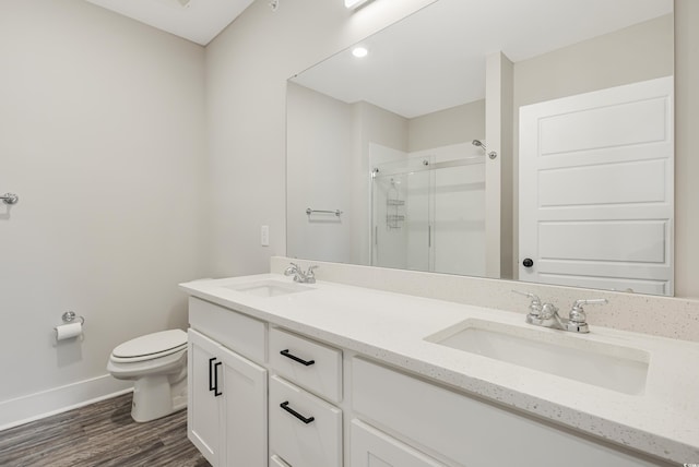 bathroom with toilet, vanity, a shower with shower door, and wood-type flooring