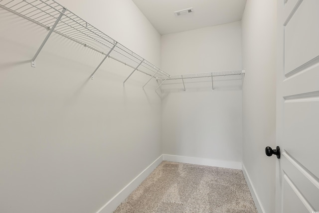 walk in closet with carpet floors