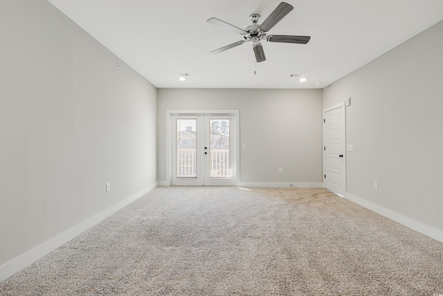 carpeted spare room with ceiling fan and french doors