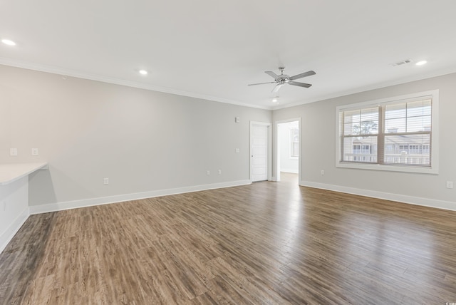 empty room featuring ceiling fan, crown molding, and dark wood-type flooring