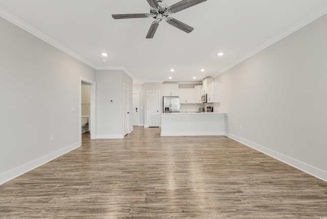 unfurnished living room featuring light hardwood / wood-style flooring, ceiling fan, and crown molding