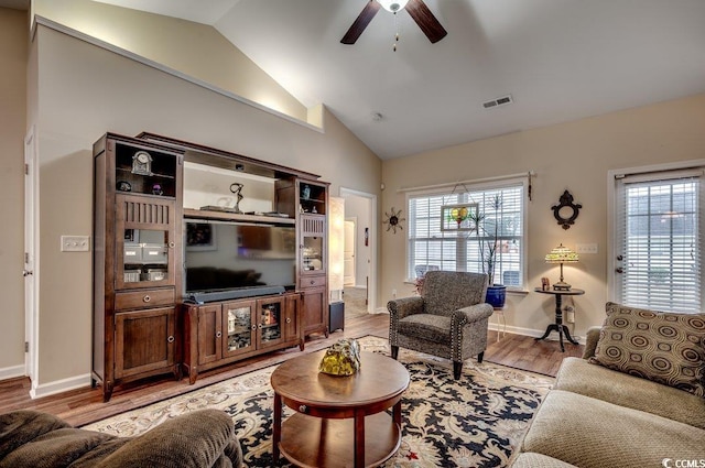 living room with ceiling fan, lofted ceiling, and light hardwood / wood-style flooring