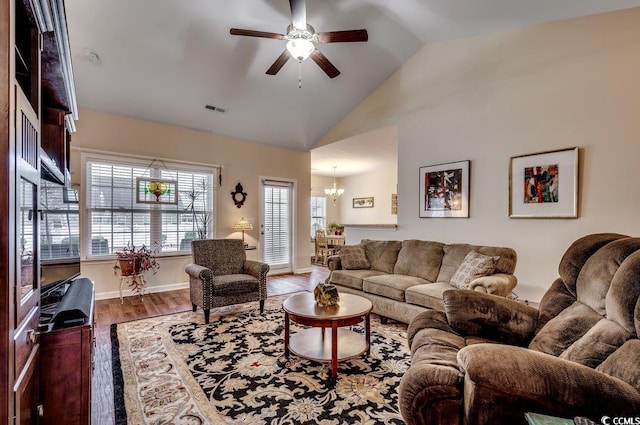 living room featuring vaulted ceiling, wood-type flooring, and ceiling fan with notable chandelier