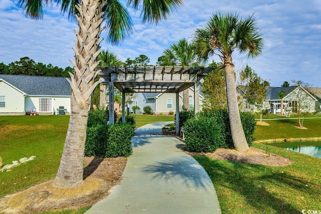 view of home's community featuring a pergola, a water view, and a lawn