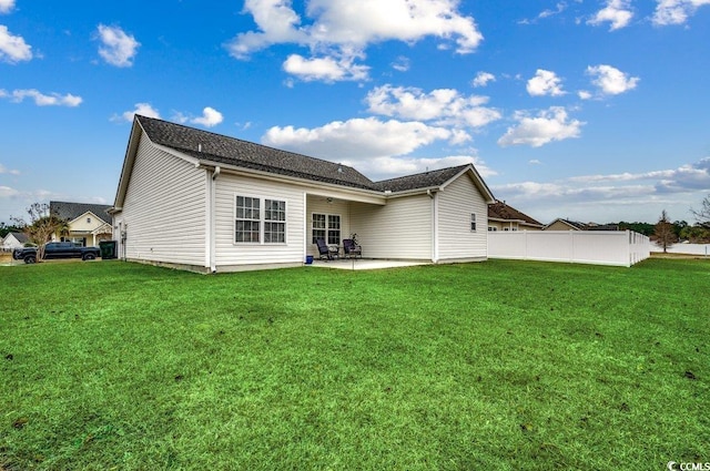 back of house featuring a lawn and a patio area