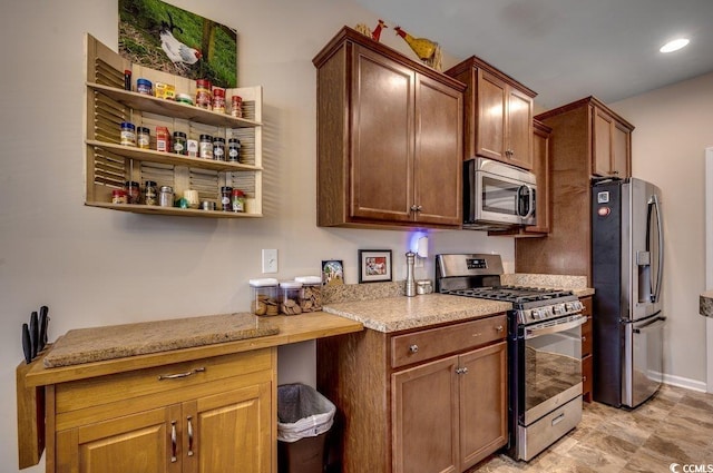 kitchen with light stone countertops and appliances with stainless steel finishes