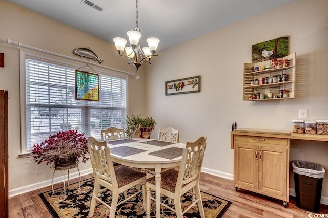 dining space featuring light hardwood / wood-style flooring and an inviting chandelier