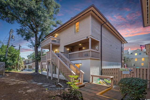 back house at dusk with a balcony