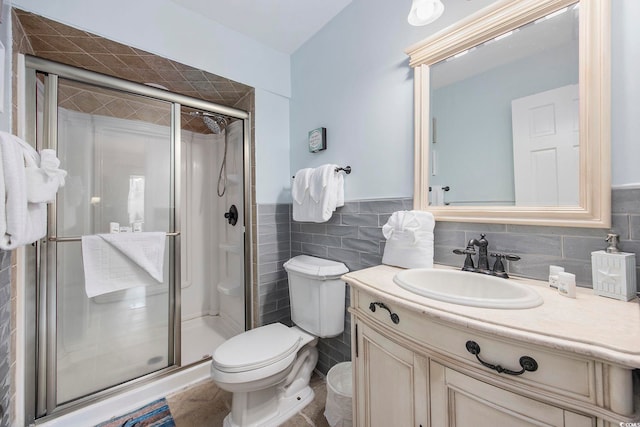 bathroom featuring vanity, toilet, tile walls, and walk in shower