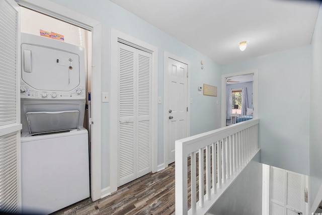 clothes washing area with stacked washer and clothes dryer and dark hardwood / wood-style floors