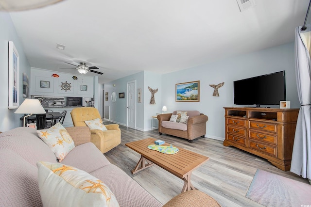 living room with ceiling fan and light wood-type flooring