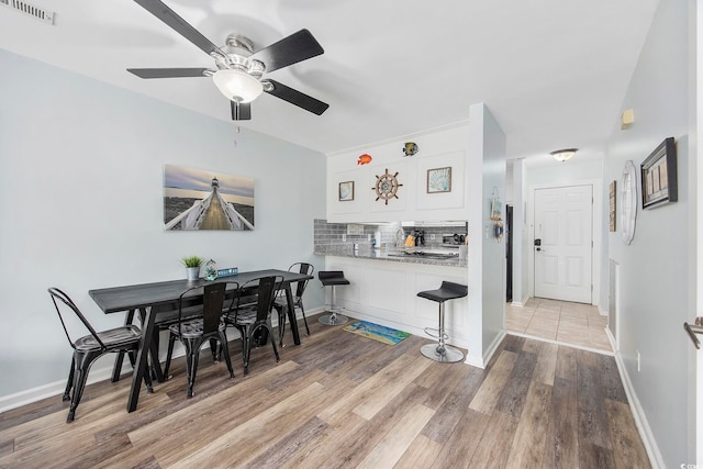 dining area with ceiling fan and light hardwood / wood-style flooring