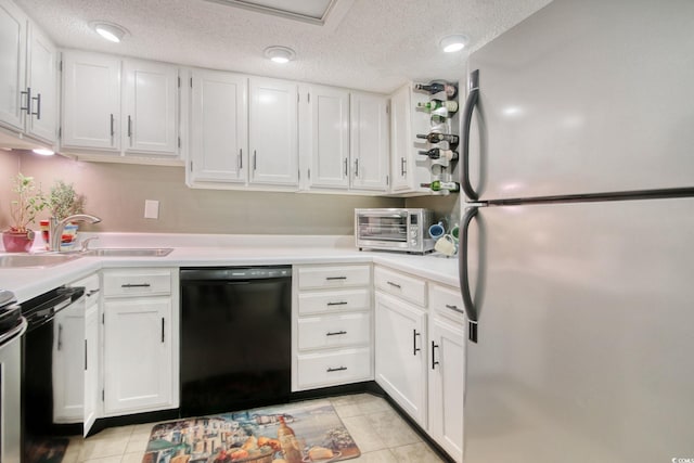 kitchen with white cabinets, stainless steel fridge, black dishwasher, and sink