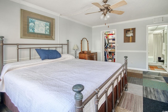 bedroom with a walk in closet, ensuite bath, ceiling fan, crown molding, and a closet