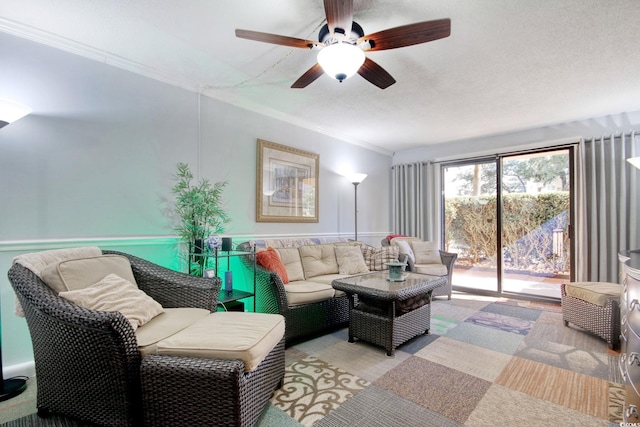 living room featuring a textured ceiling, ceiling fan, light colored carpet, and crown molding