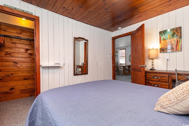 carpeted bedroom with wood ceiling and wood walls