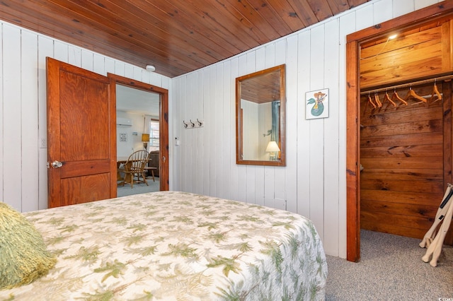 carpeted bedroom featuring wooden walls and wood ceiling