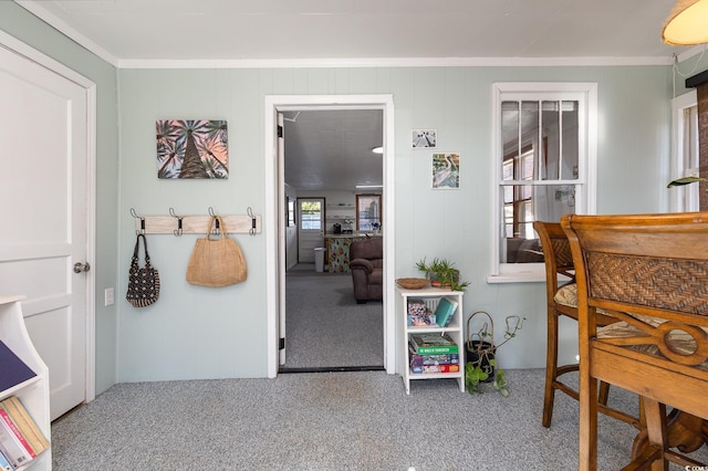 carpeted dining area featuring crown molding