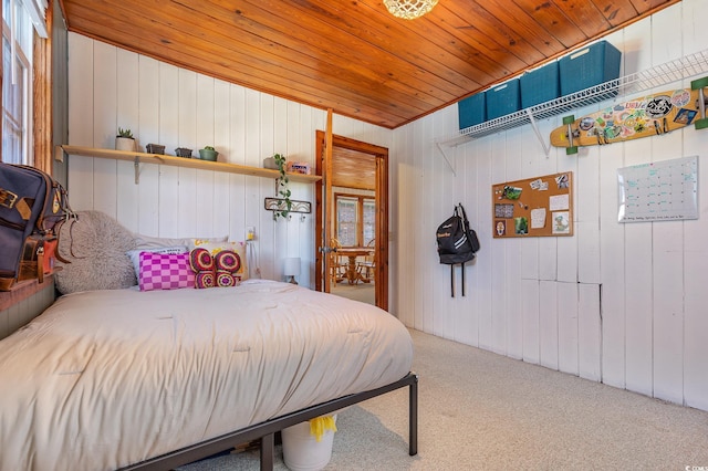 carpeted bedroom featuring wood walls and wood ceiling