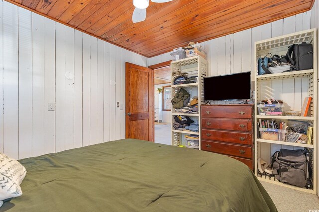 bedroom featuring carpet floors, wooden walls, ceiling fan, and wood ceiling