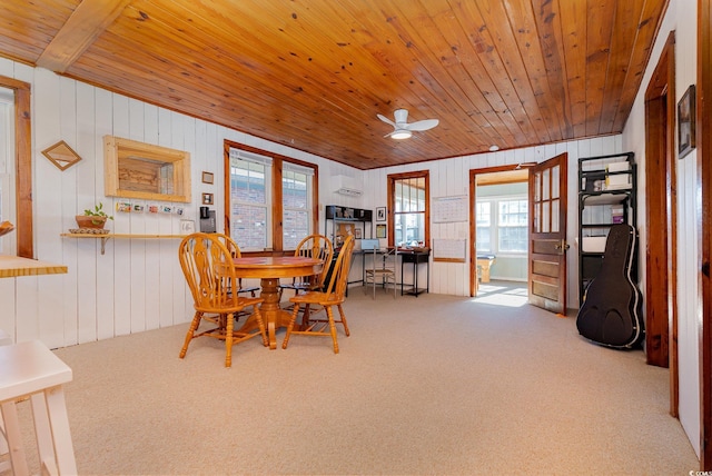 carpeted dining room featuring a wall unit AC, ceiling fan, wooden ceiling, and wood walls