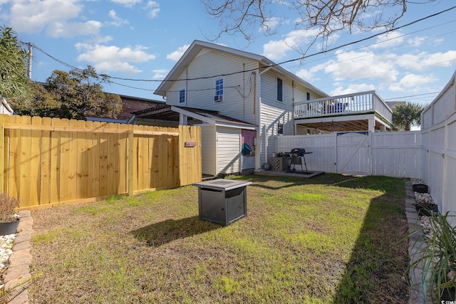 rear view of house featuring a wooden deck, a storage shed, and a lawn