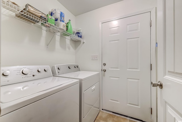 laundry room featuring washing machine and dryer and light tile patterned flooring