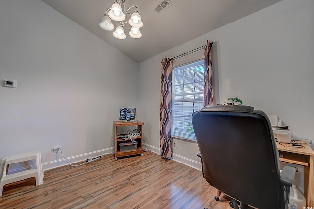 office featuring a healthy amount of sunlight, light wood-type flooring, an inviting chandelier, and vaulted ceiling