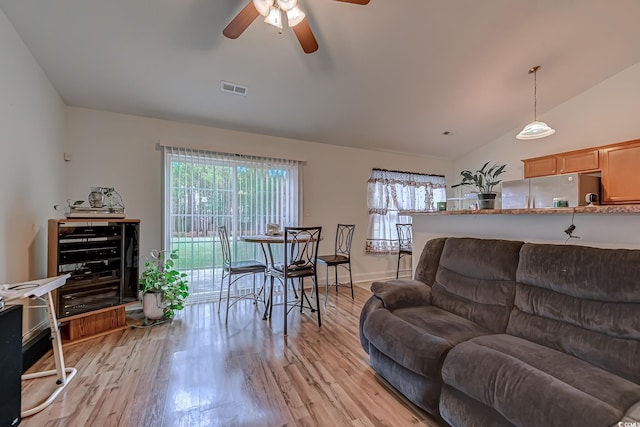 living room featuring vaulted ceiling, ceiling fan, a healthy amount of sunlight, and light hardwood / wood-style floors