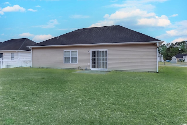 rear view of property featuring a lawn