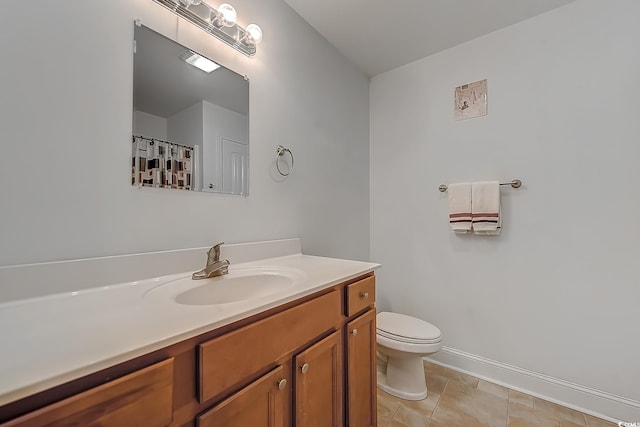 bathroom featuring toilet, tile patterned floors, and vanity