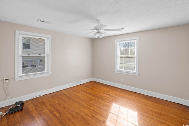 spare room with hardwood / wood-style flooring, ceiling fan, and a textured ceiling