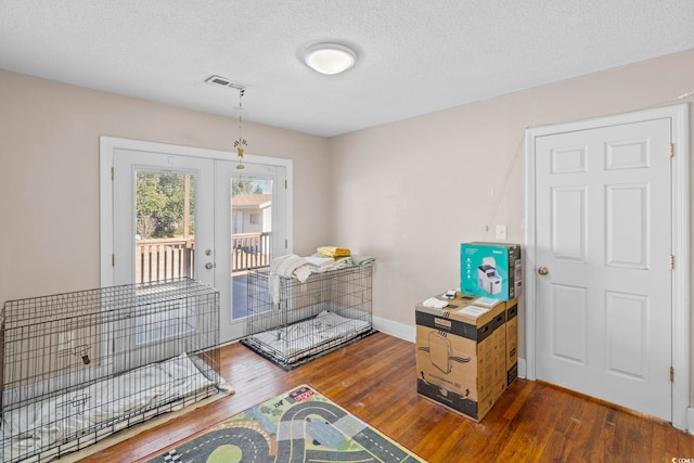 interior space with french doors, a textured ceiling, and dark wood-type flooring