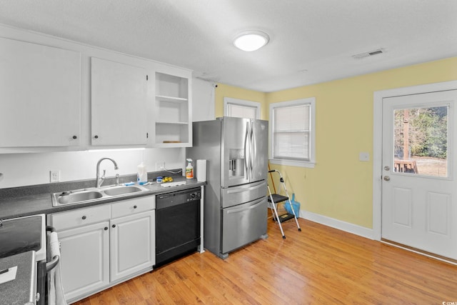 kitchen with white cabinets, sink, stainless steel refrigerator with ice dispenser, black dishwasher, and a healthy amount of sunlight