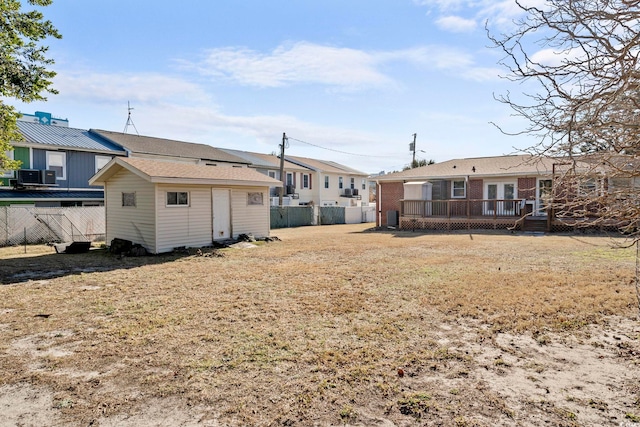 rear view of property featuring a shed and a deck