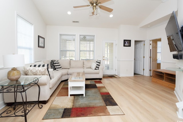 living room featuring ceiling fan, light wood-type flooring, and vaulted ceiling