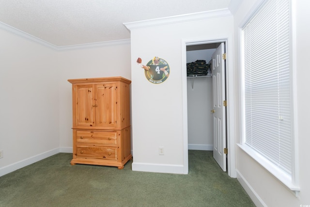 unfurnished bedroom featuring a walk in closet, crown molding, and dark carpet