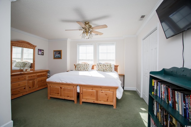 carpeted bedroom with ceiling fan, crown molding, and a closet