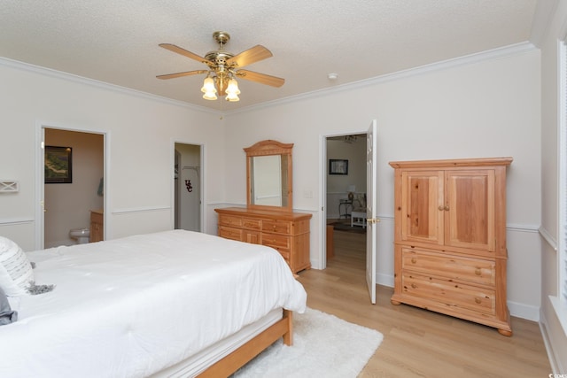 bedroom with ceiling fan, crown molding, light hardwood / wood-style floors, and ensuite bath