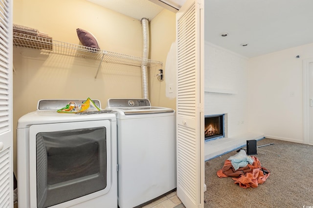 laundry room featuring light carpet, washer and clothes dryer, and a fireplace