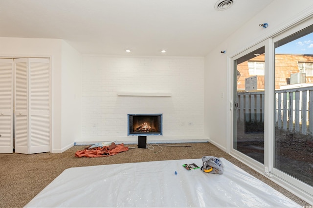 interior space featuring access to exterior, brick wall, a closet, and carpet flooring