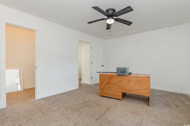 unfurnished office with ceiling fan and carpet