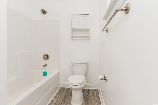 bathroom featuring wood-type flooring, shower / washtub combination, and toilet