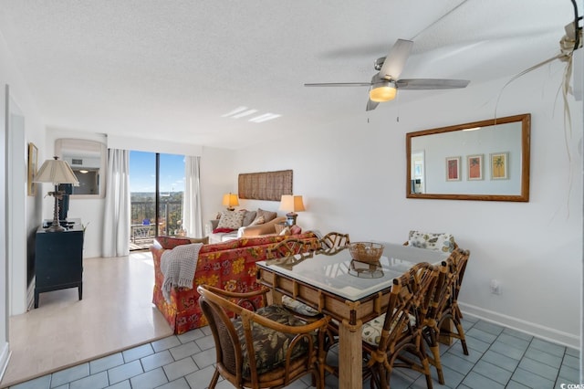 tiled dining area featuring ceiling fan, floor to ceiling windows, and a textured ceiling